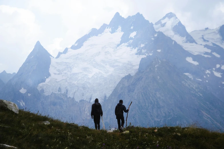 a couple of people that are standing in the grass, by Alexander Runciman, pexels contest winner, snowy peaks, hunting, avatar image, herzog de meuron