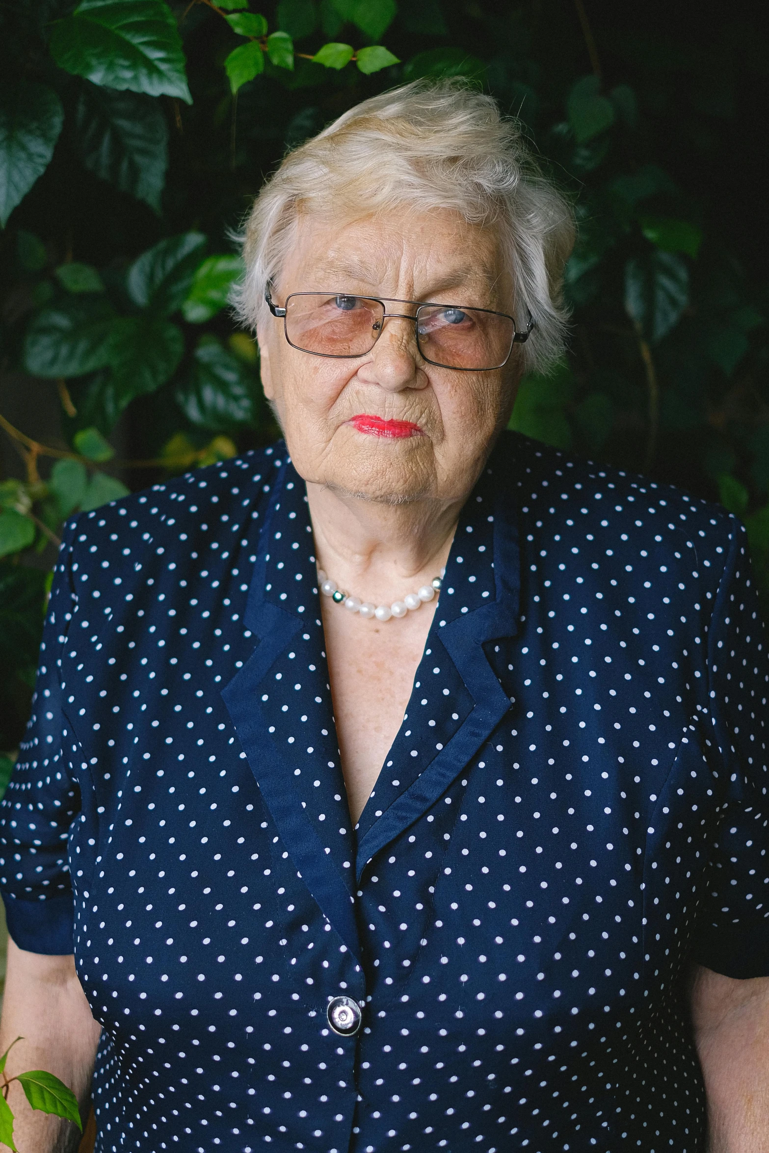 an older woman standing in front of a bush, unsplash, photorealism, formal portrait, world war 2 portrait photo, studio photo portrait, a high angle shot