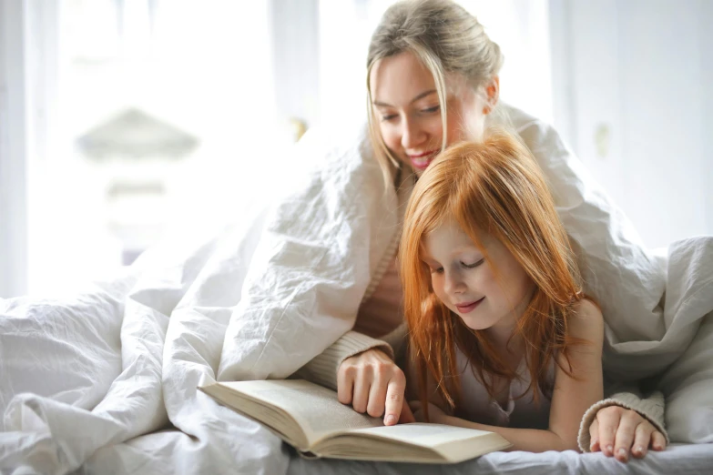 a woman and a little girl laying in bed reading a book, pexels, figuration libre, ( redhead, with a white background, multiple stories, a blond