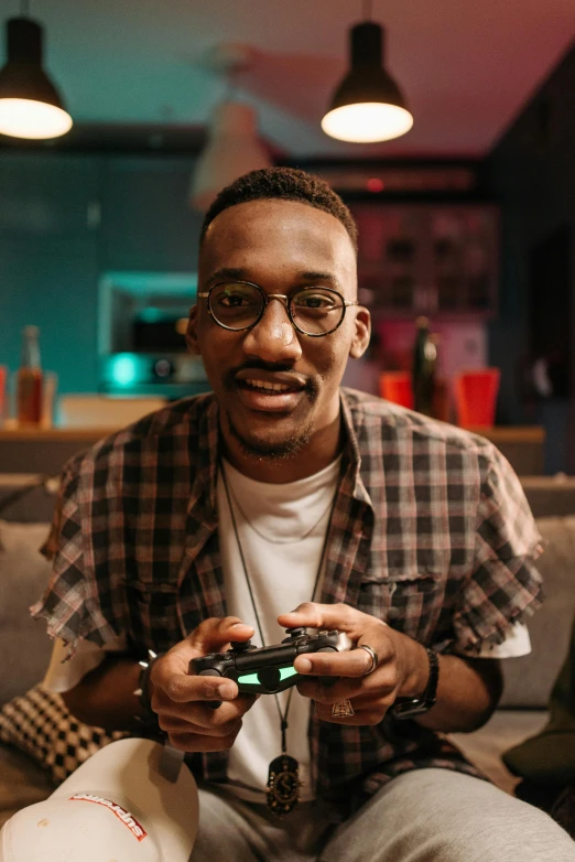 a man sitting on a couch playing a video game, by Amos Ferguson, pexels contest winner, ( ( dark skin ) ), headshot profile picture, ashteroth, looking confident