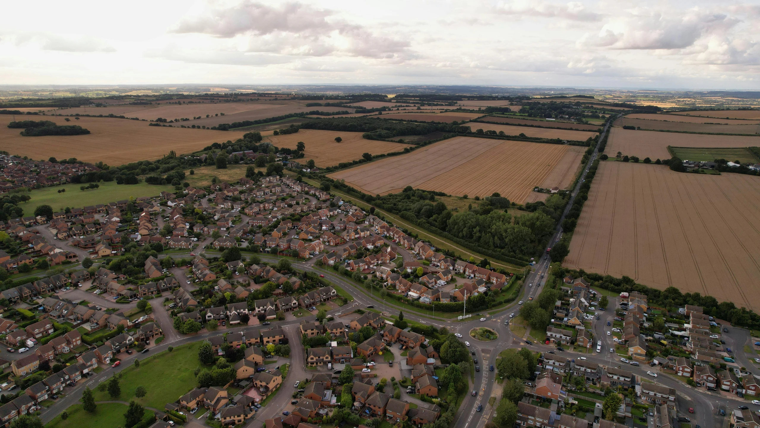 an aerial view of a town surrounded by fields, unsplash, chesterfield, suburbia street, 4k image”, wide angle”