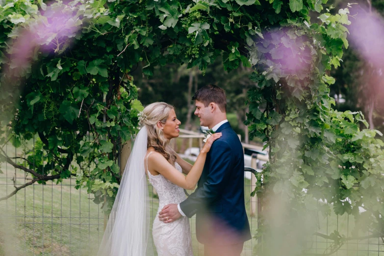 a bride and groom look into each other's eyes, by Tom Bonson, pexels contest winner, covered in vines, lachlan bailey, lilacs, low quality footage