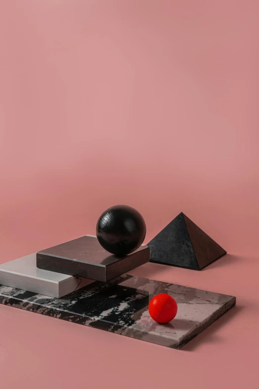 a black object sitting on top of a table next to a red ball, an abstract sculpture, inspired by Bauhaus, unsplash contest winner, hypermodernism, pink marble building, behance lemanoosh, large triangular shapes, 4 k product photo