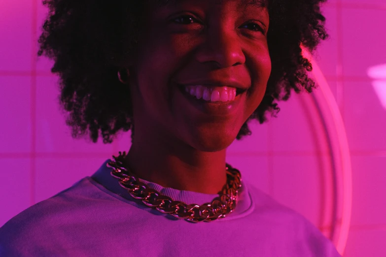 a close up of a person wearing a necklace, an album cover, pexels contest winner, afrofuturism, cheerful ambient lighting, ((purple)), wearing a gold chain, happy lighting