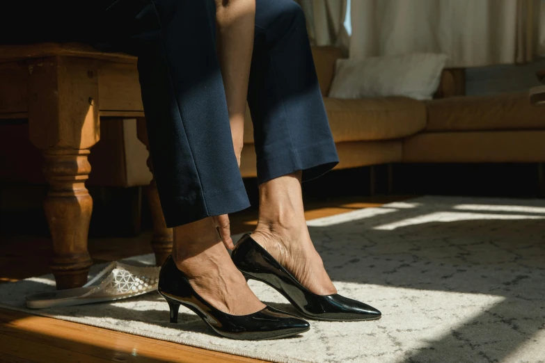 a close up of a person wearing high heels, trending on pexels, wearing a black suit, at home, on the ground, curated collections