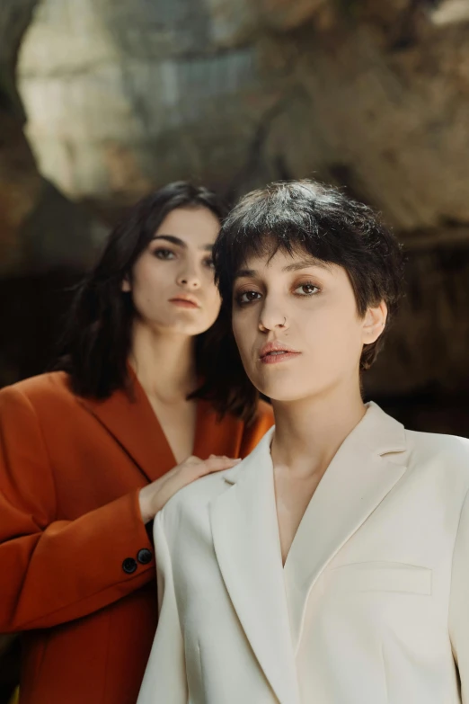a couple of women standing next to each other, an album cover, by irakli nadar, with short hair, in a cave, official store photo, portrait image