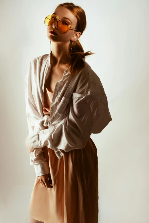 a woman standing in front of a white wall, by Nina Hamnett, trending on unsplash, renaissance, wear's beige shirt, flowing sakura silk, cropped shirt with jacket, soft studio lighting