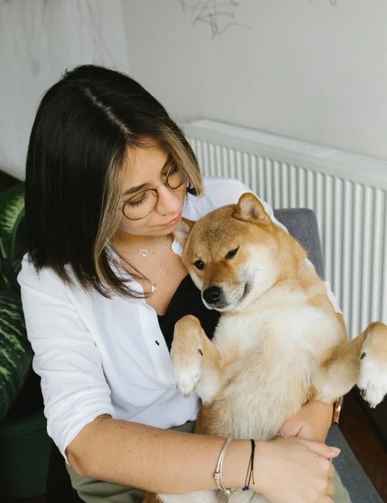 a woman sitting on a couch holding a dog, trending on unsplash, shiba figurine, hugging each other, fluffy neck, profile image