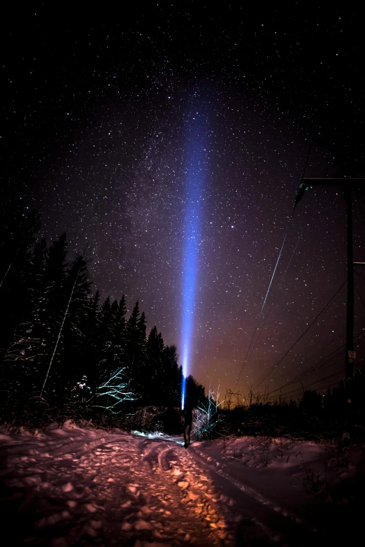 a person standing in the snow under a light beam, by Anato Finnstark, rocket launch, stunning ski, blue