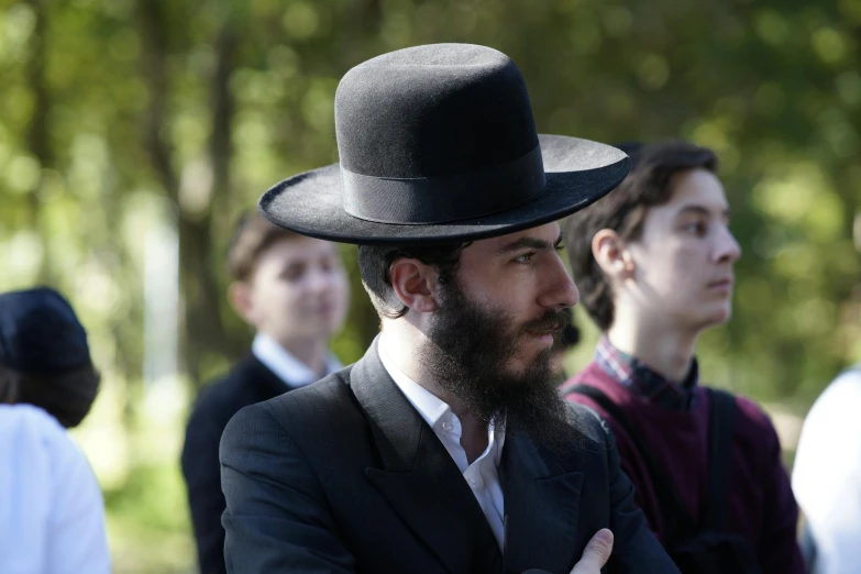 a man with a beard wearing a black hat, sholim, of a family standing in a park, zachary corzine, ceremony