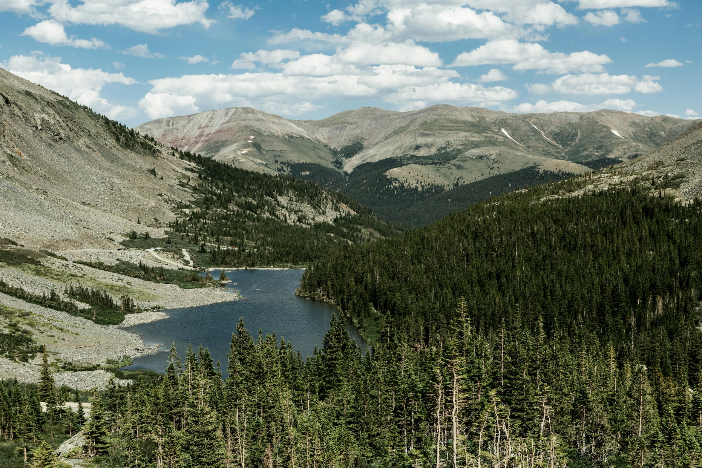 a large body of water sitting in the middle of a forest, a photo, by Morgan Russell, pexels contest winner, colorado mountains, high elevation, panoramic view, fan favorite