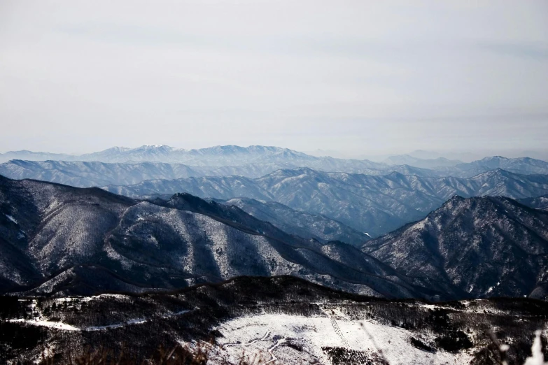a man riding a snowboard on top of a snow covered slope, pexels contest winner, sōsaku hanga, sparse mountains on the horizon, joongwon jeong, “ aerial view of a mountain, (3 are winter
