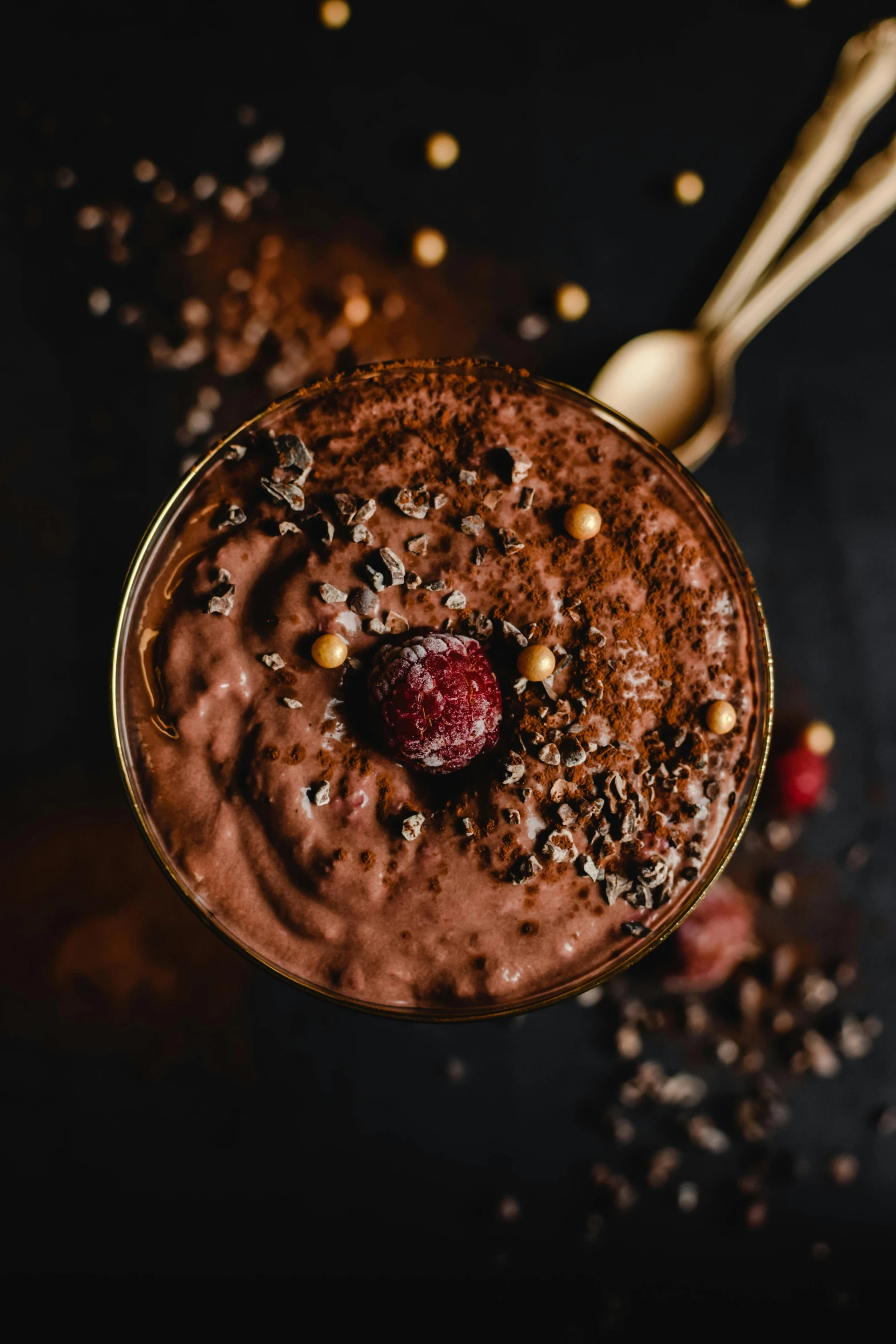 a glass filled with chocolate pudding next to a spoon, trending on pexels, renaissance, black forest, seeds, striking pose, gif