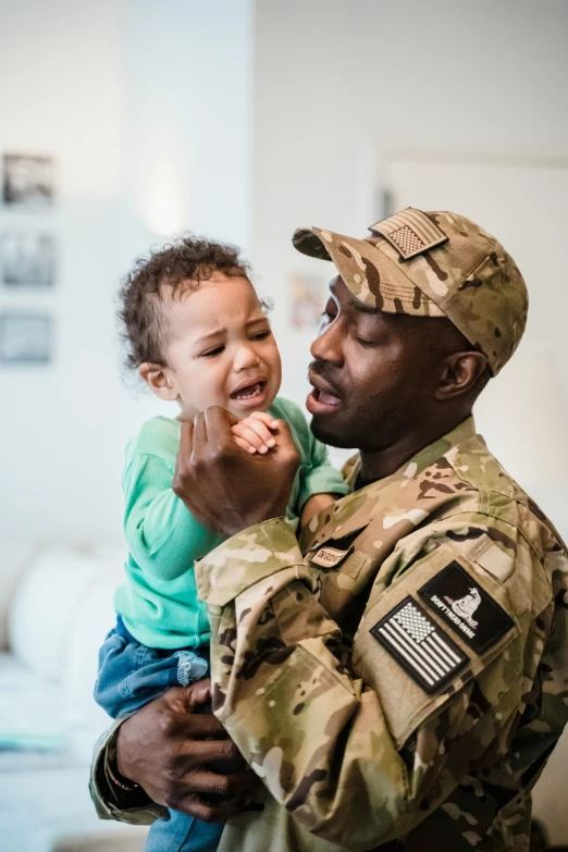 a soldier holding a child in his arms, pexels contest winner, african american, caring fatherly wide forehead, worried, slide show