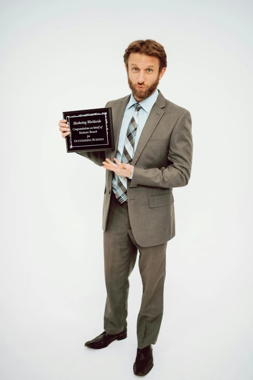 a man in a suit holding a plaque, inspired by John E. Berninger, trending on reddit, charlie day, award winning press photo, full body! shot, limmy