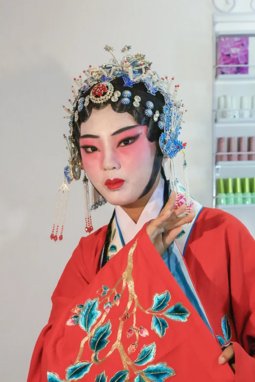 a woman in a red kimono is posing for a picture, inspired by Xie Huan, make up, on display, square, production photo