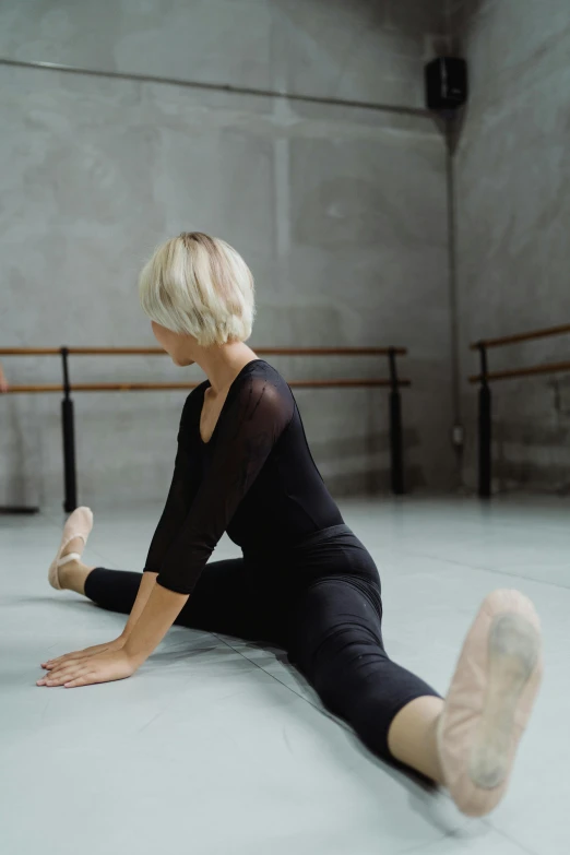 a woman sitting on the floor in a dance studio, unsplash, arabesque, square, low quality photo, low detail, blonde