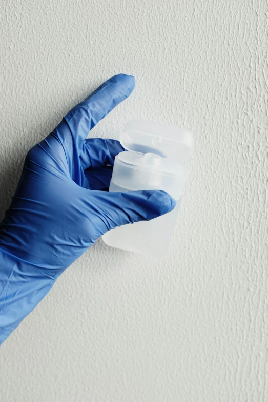 a person in a blue glove holding a piece of plastic, dissolution filter, on a pale background, d-cup, dermal implants
