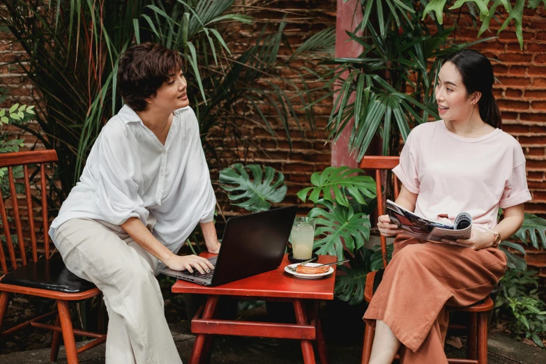 two women sitting at a table with a laptop, trending on pexels, jungle setting, avatar image, full frame image