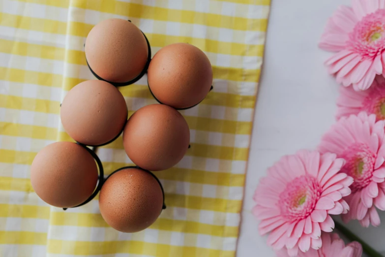 a bunch of eggs sitting on top of a table, a still life, trending on pexels, pink yellow flowers, 🦩🪐🐞👩🏻🦳, product shot, filling the frame