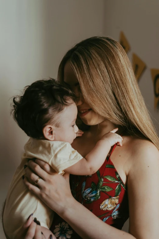 a woman holding a baby in her arms, pexels contest winner, looking her shoulder, they are close to each other, alana fletcher, high quality screenshot