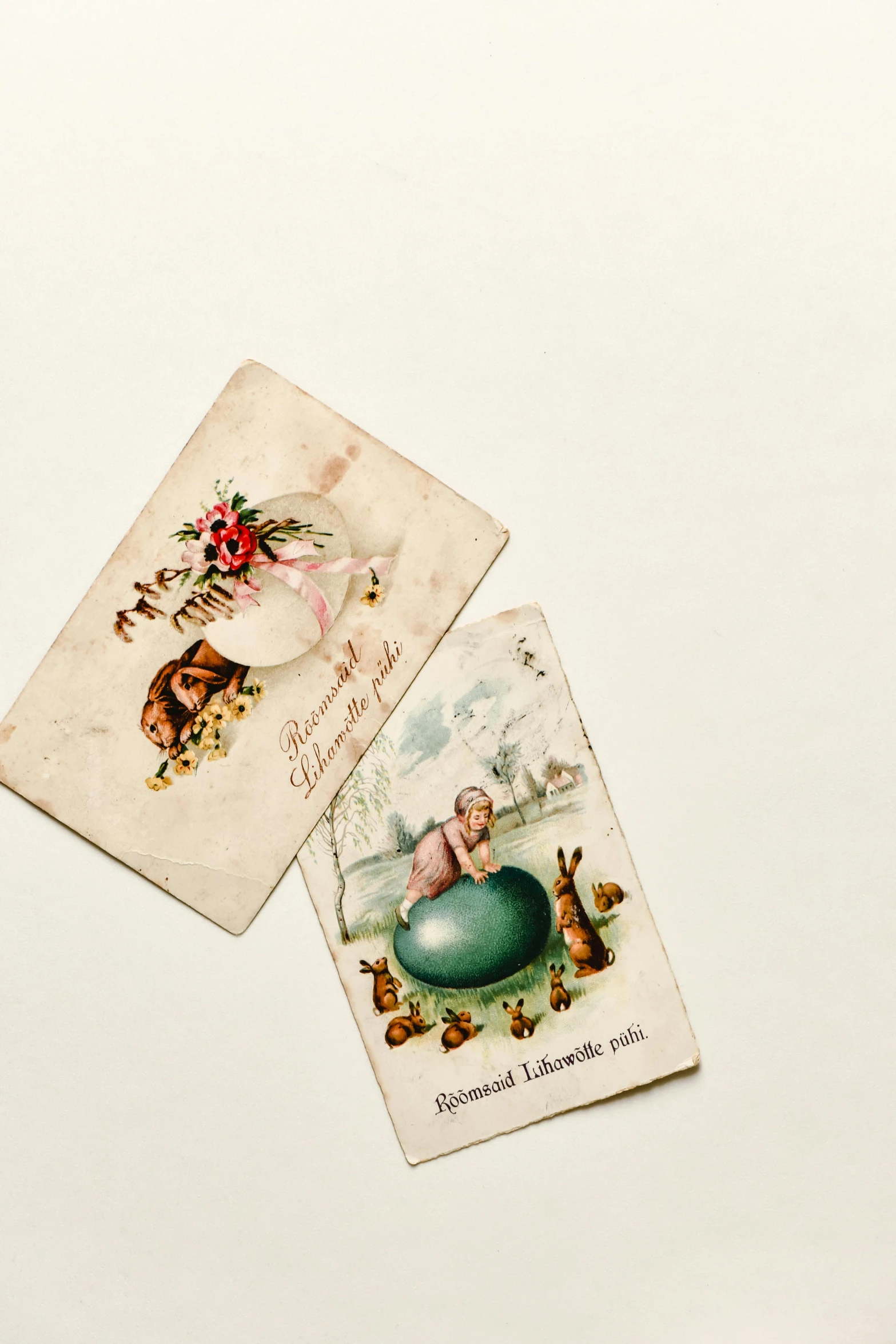 a couple of cards sitting on top of a table, an egg, victorian era, on a white table, - 6