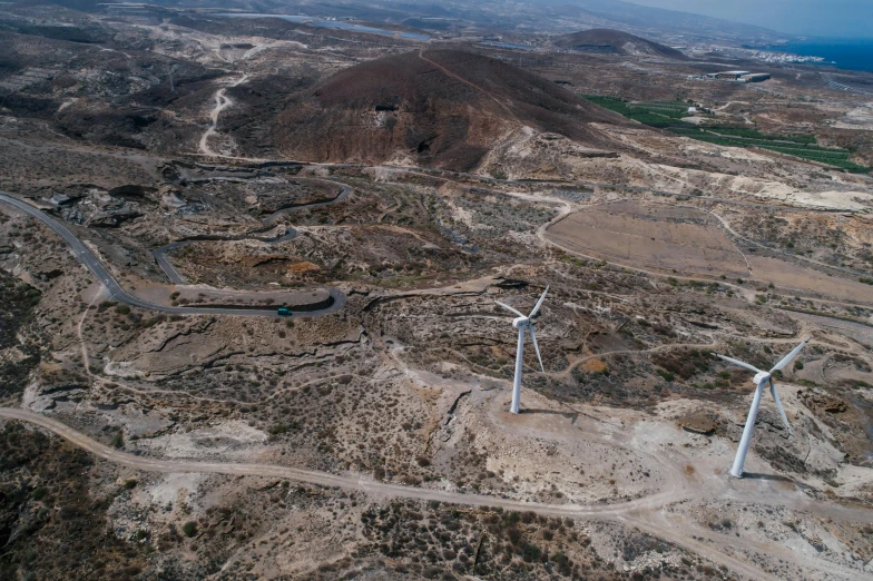 a group of wind turbines sitting on top of a dirt field, les nabis, aerial view of an ancient land, cover. photo : david roemer, jerusalem, bjarke ingels