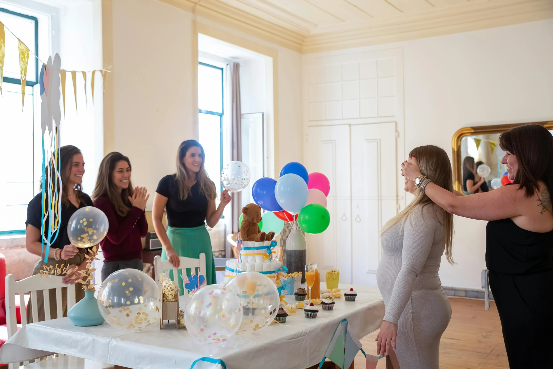 a group of women standing around a table with balloons, by Arabella Rankin, pexels contest winner, maternity feeling, avatar image, decoration around the room, panoramic shot