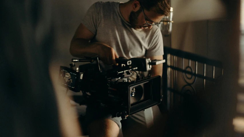 a man holding a camera in a room, production ig, **cinematic, mid - action