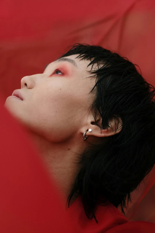 a close up of a person holding an umbrella, an album cover, inspired by Gao Xiang, hyperrealism, red contact lenses, left ear, androgyny, covered in coral