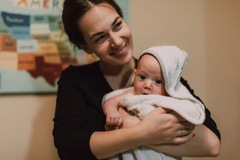 a woman holding a baby wrapped in a towel, a photo, by Emma Andijewska, lachlan bailey, avatar image, 278122496, profile photo