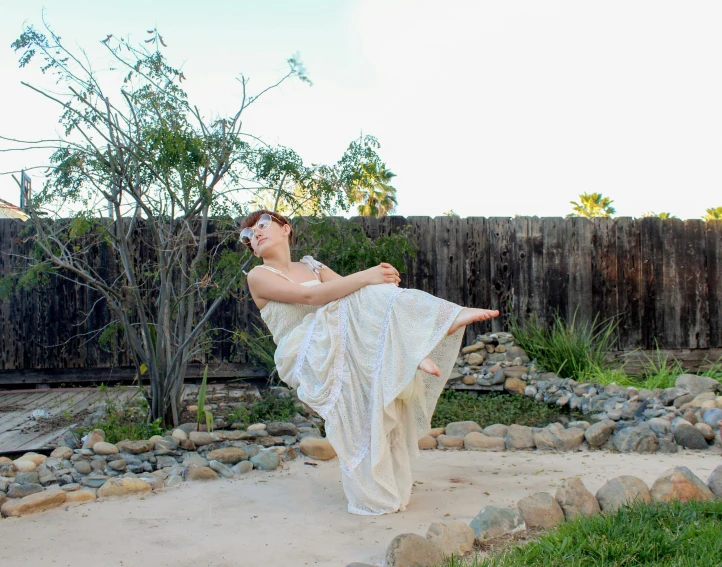 a woman in a wedding dress doing a yoga pose, by Hannah Tompkins, arabesque, backyard, promo image, spreading her wings, modeled