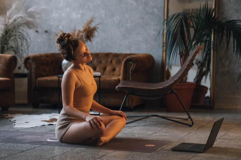 a woman sitting on a yoga mat in a living room, by Emma Andijewska, pexels contest winner, renaissance, in a gym, brown, profile image, thumbnail