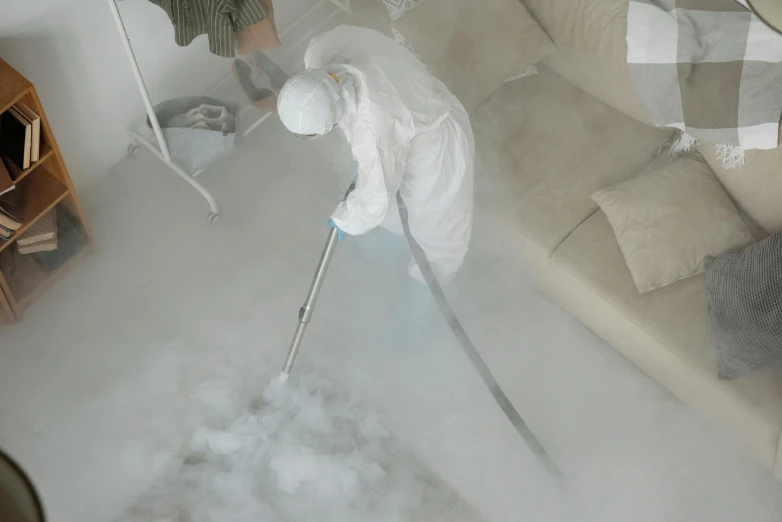 a person using a steam mop in a living room, an airbrush painting, by Daniel Lieske, pexels, process art, white thick smoke, hazmat suits, low quality footage, a high angle shot