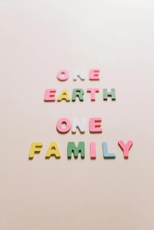 a sign that says one earth one family, by Anita Malfatti, trending on unsplash, international typographic style, made of candy, pastel clothing, profile picture, instagram picture