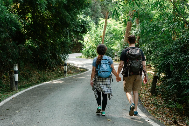 a couple of people that are walking down a road, pexels contest winner, in a tropical forest, avatar image, a backpack, couple