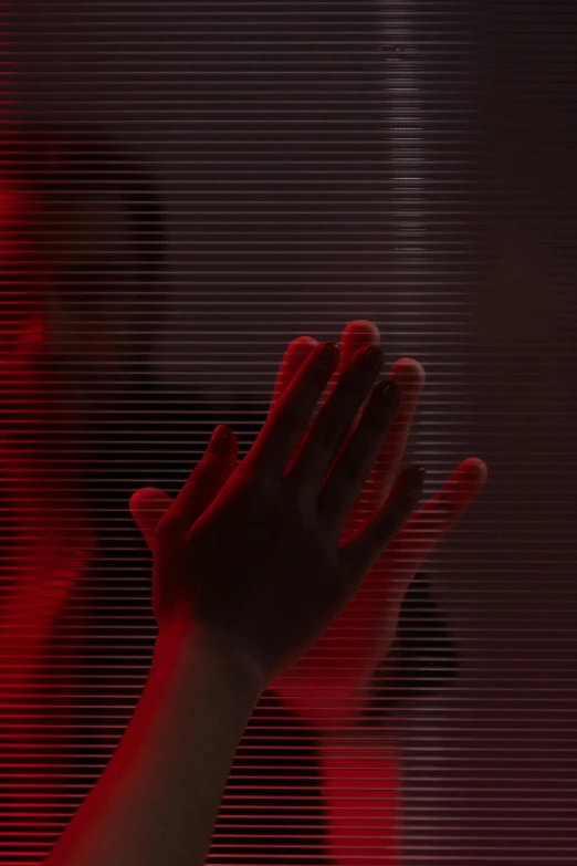 a person holding their hands up in front of a red light, inspired by Ryoji Ikeda, holography, crawling out of a dark room, promo image, face partially obscured, looking out a window