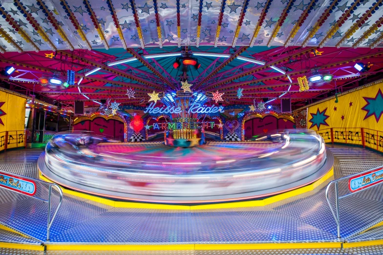 a merry go round ride at a carnival, by Julia Pishtar, maximalism, lined with neon tube lights, large scale photo, speed racer, softplay