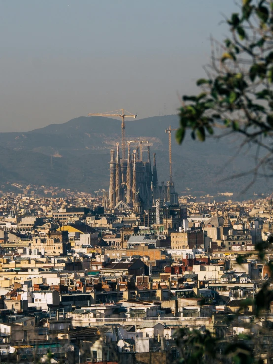 a view of a city from the top of a hill, inspired by Modest Urgell, pexels contest winner, happening, gaudi sagrada familia, 🚿🗝📝