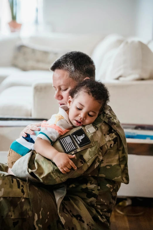 a soldier holding a child in his arms, unsplash, at home, square, resting, healthcare