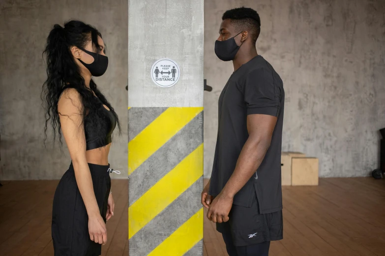 a man and a woman standing next to each other, black facemask, athletic build, profile image, modelling