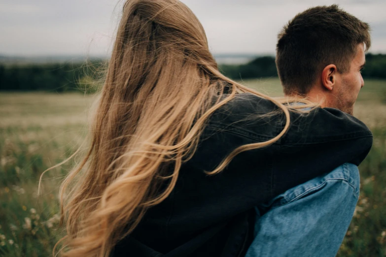 a man and a woman standing in a field, trending on pexels, happening, back of the hair, teenage girl, over the shoulder closeup, windy hair