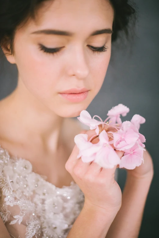 a woman in a wedding dress holding a bouquet of flowers, inspired by Marie Laurencin, unsplash, romanticism, flowing sakura silk, prima ballerina, close face view, made of silk paper