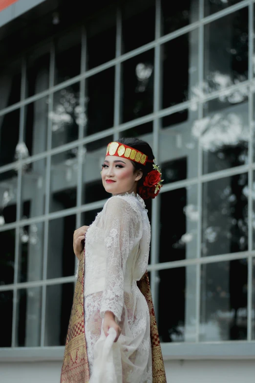 a woman in a white dress standing in front of a building, pexels contest winner, sumatraism, formal attire, batik, gif, square