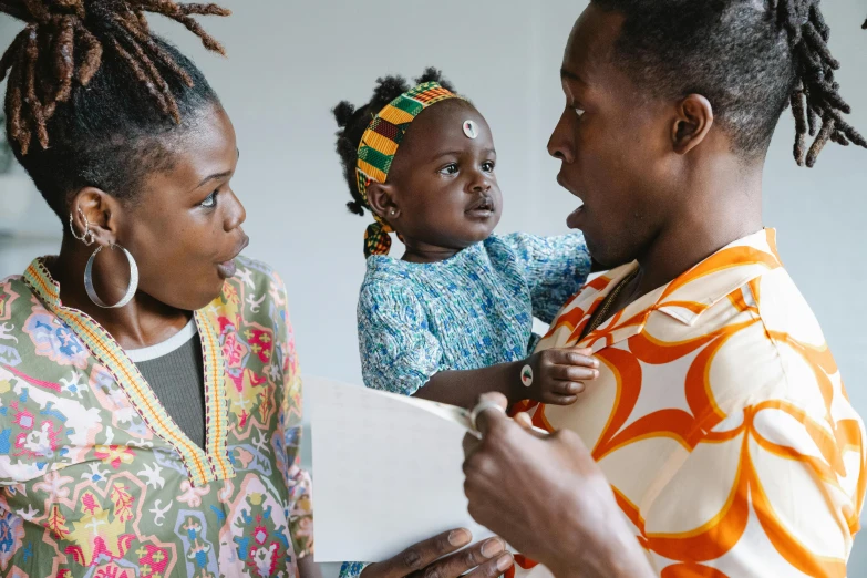 a woman holding a baby while standing next to another woman, by Daniel Lieske, pexels contest winner, afrofuturism, caring fatherly wide forehead, wearing an african dress, telling stories, a handsome