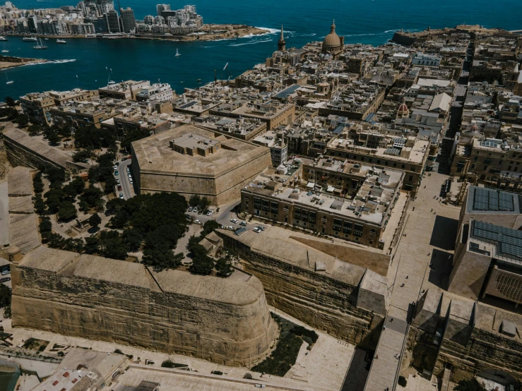 an aerial view of a city in the middle of the ocean, pexels contest winner, fortresses, brown, military buildings, buildings carved out of stone