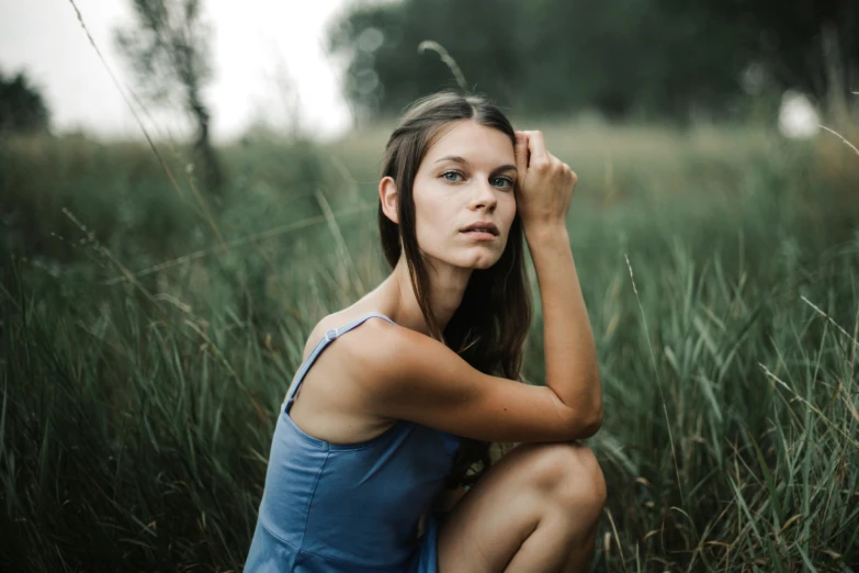 a woman squatting in a field of tall grass, a portrait, by Emma Andijewska, pexels contest winner, clean face and body skin, wearing a camisole, 15081959 21121991 01012000 4k, blue
