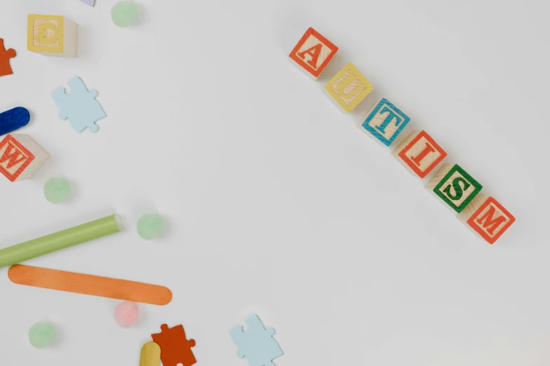 a white table topped with lots of wooden toys, inspired by Cerith Wyn Evans, trending on unsplash, background image, confetti, letter a, blank background