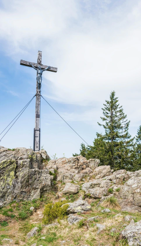 a cross sitting on top of a rocky hill, black forest, chairlifts, commercially ready, no cropping