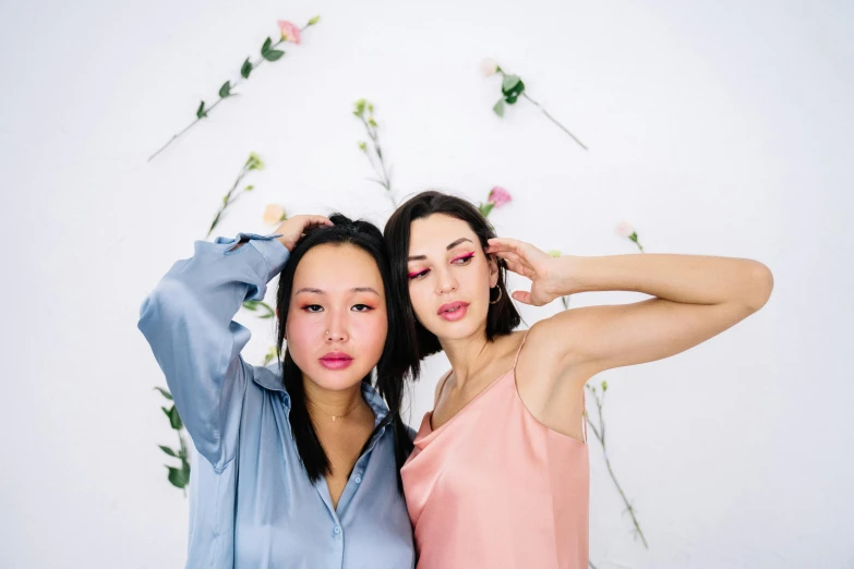 a couple of women standing next to each other, inspired by Wang Duo, trending on pexels, aestheticism, pink skin, blue, brunettes, asian human